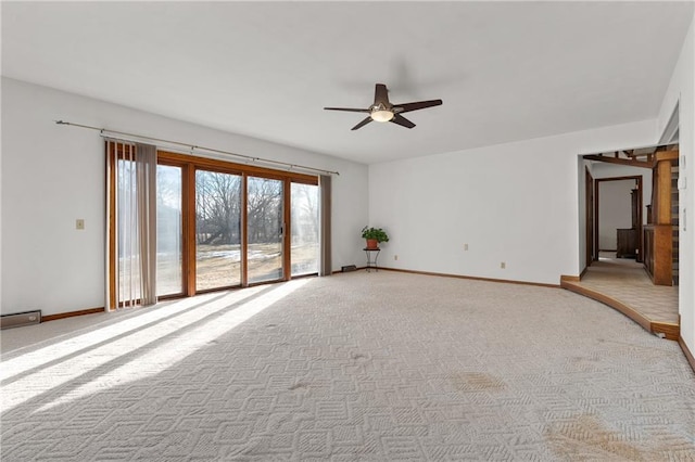 unfurnished room featuring light carpet, baseboards, and a ceiling fan