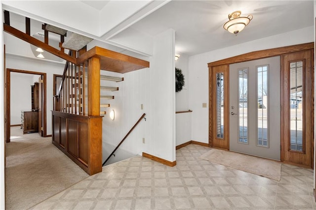 foyer entrance featuring light floors and baseboards