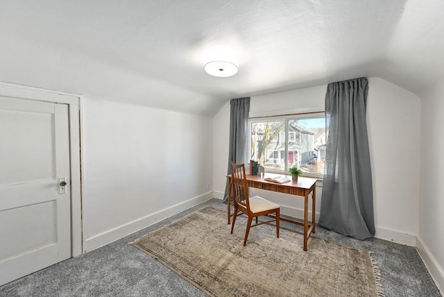 carpeted office with lofted ceiling and baseboards