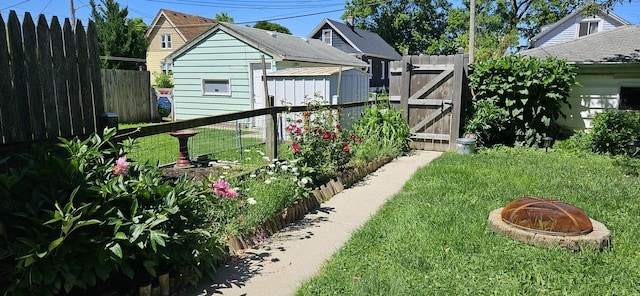 view of yard featuring an outdoor fire pit, fence, and a gate