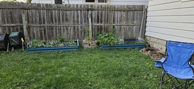 view of yard with fence and a garden