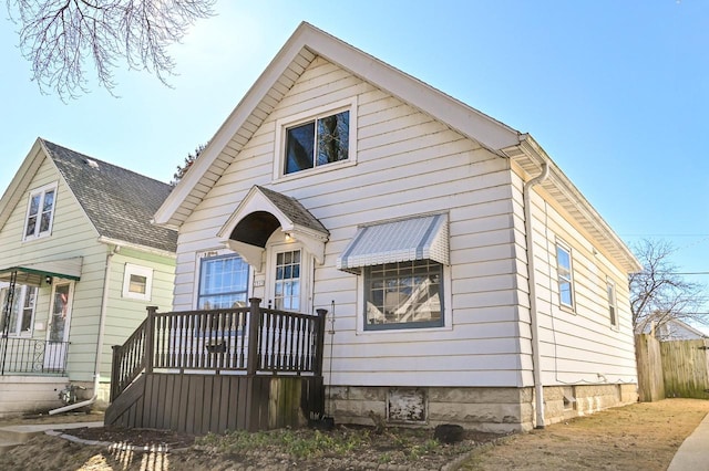 view of front of home with a shingled roof and fence