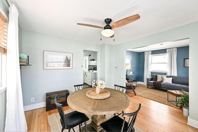 dining space featuring light wood-type flooring, ceiling fan, and baseboards