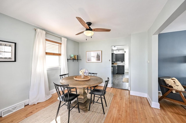 dining area with visible vents, light wood-style flooring, and baseboards