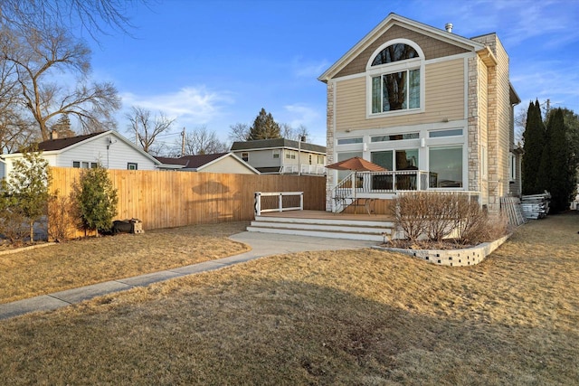 back of house featuring fence and a wooden deck