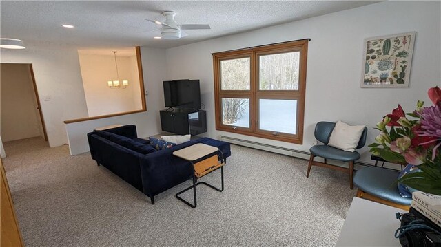 14091 W County Highway B, Hayward, WI 54843 - carpeted living area featuring a textured ceiling, baseboard heating, and ceiling fan with notable chandelier