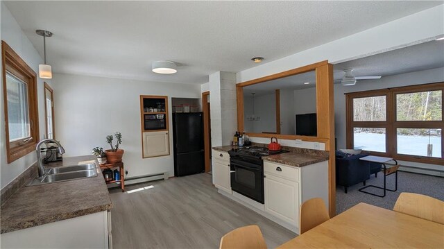 14091 W County Highway B, Hayward, WI 54843 - kitchen with light wood-style flooring, white cabinets, a sink, a textured ceiling, and black appliances