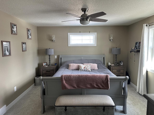 bedroom with light carpet, a textured ceiling, and baseboards