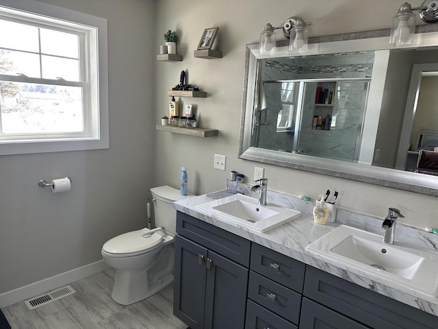 full bath featuring toilet, a stall shower, visible vents, and a sink