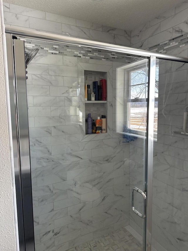 full bathroom featuring a stall shower and a textured ceiling