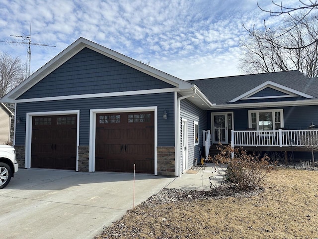 single story home with a garage, covered porch, stone siding, and concrete driveway