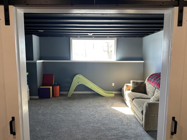 playroom with carpet, baseboards, and a barn door