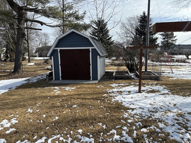 snow covered structure with a storage unit and an outbuilding