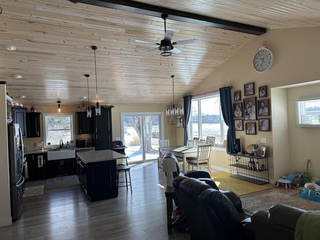 living room with lofted ceiling with beams, plenty of natural light, wood finished floors, and wooden ceiling