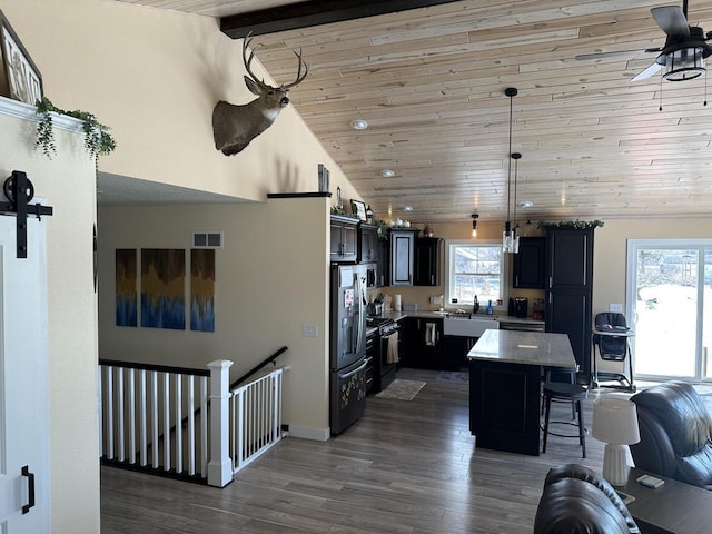 kitchen with dark wood finished floors, wood ceiling, a kitchen island, a kitchen breakfast bar, and stainless steel fridge with ice dispenser