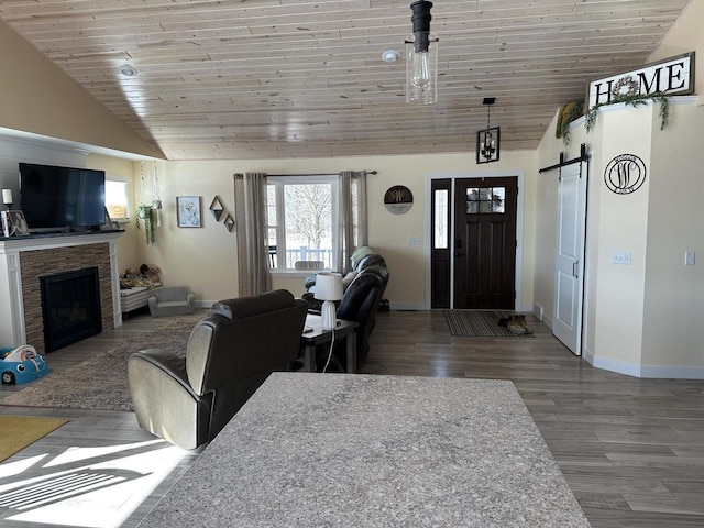 living area with lofted ceiling, a barn door, wood finished floors, and wood ceiling