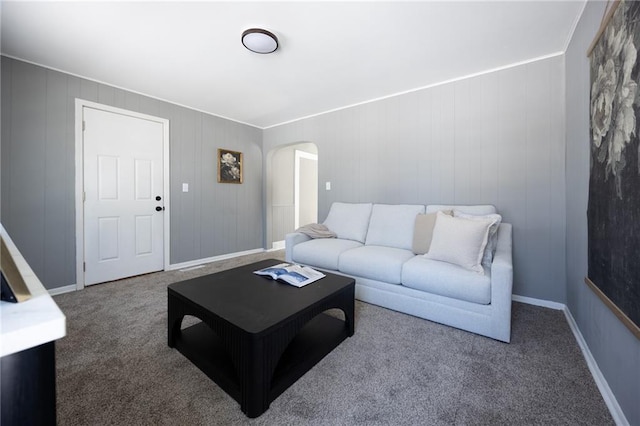 living room featuring carpet, arched walkways, and baseboards