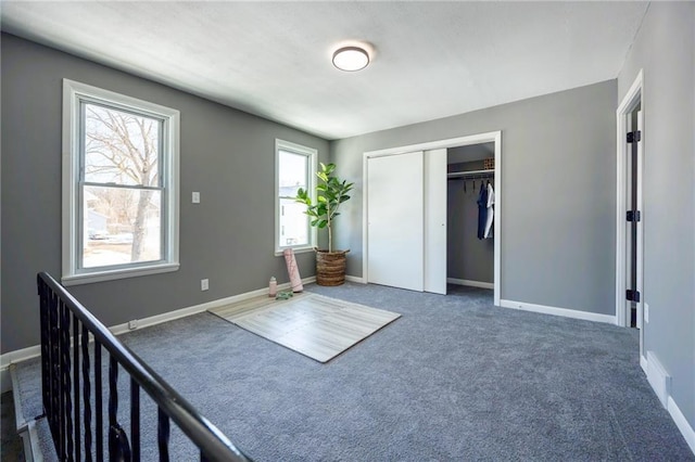 unfurnished bedroom with a closet, carpet flooring, and baseboards