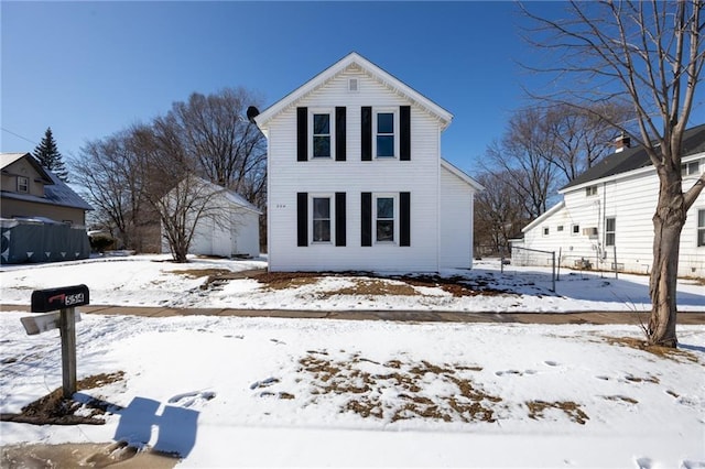 snow covered property featuring a detached garage