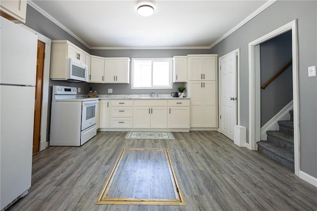 kitchen featuring ornamental molding, wood finished floors, white appliances, white cabinets, and light countertops