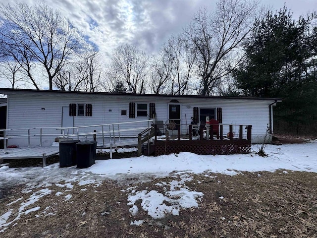 snow covered house featuring a wooden deck