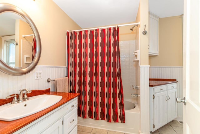 bathroom featuring a wainscoted wall, shower / bath combo with shower curtain, vanity, and tile patterned floors