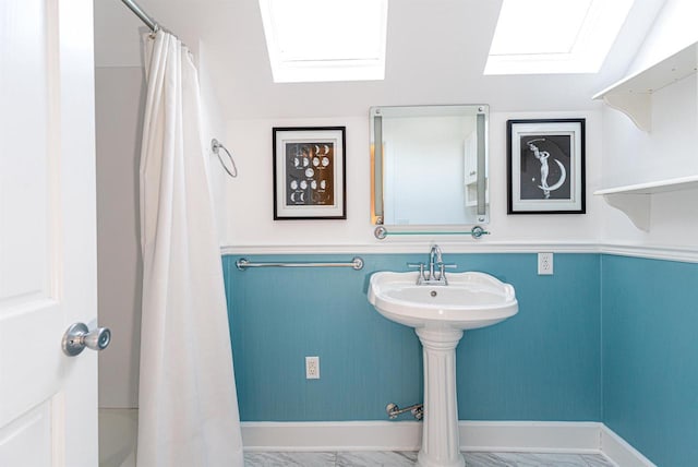 bathroom featuring marble finish floor, baseboards, and curtained shower