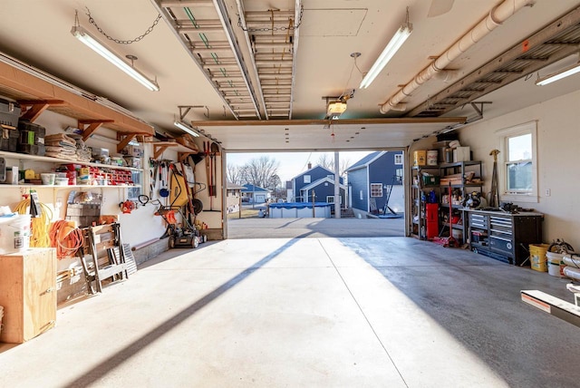 garage with a workshop area, a trampoline, and a garage door opener