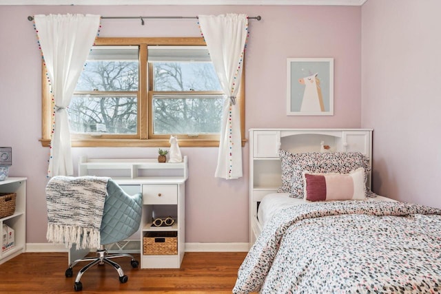 bedroom with baseboards and wood finished floors