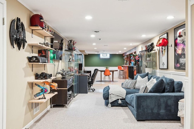 carpeted living area with a wainscoted wall and recessed lighting