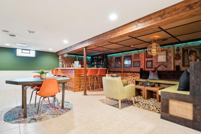 dining room with a bar, recessed lighting, visible vents, and wainscoting