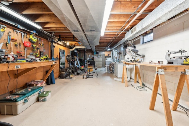 unfinished below grade area featuring a workshop area, washer / clothes dryer, and visible vents