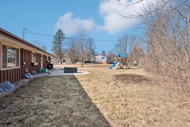 view of yard featuring a playground and a patio area