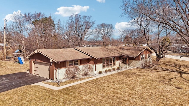 view of front of house with a front yard, driveway, an attached garage, a playground, and board and batten siding