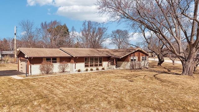 single story home featuring aphalt driveway, an attached garage, brick siding, and a front lawn