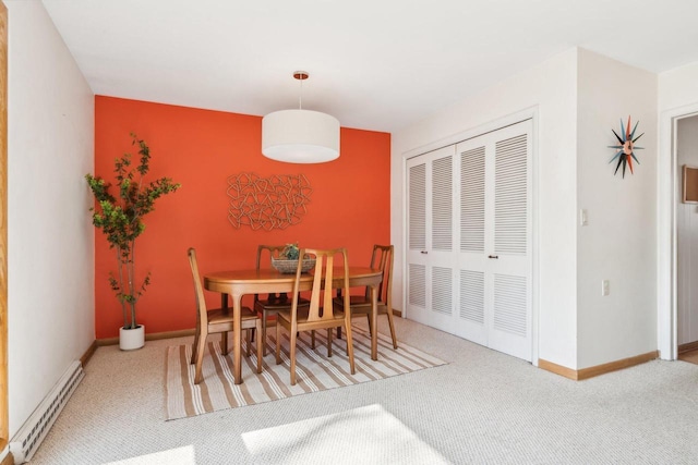 dining room featuring baseboard heating, carpet, and baseboards