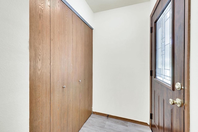 foyer entrance featuring baseboards and light wood-style floors