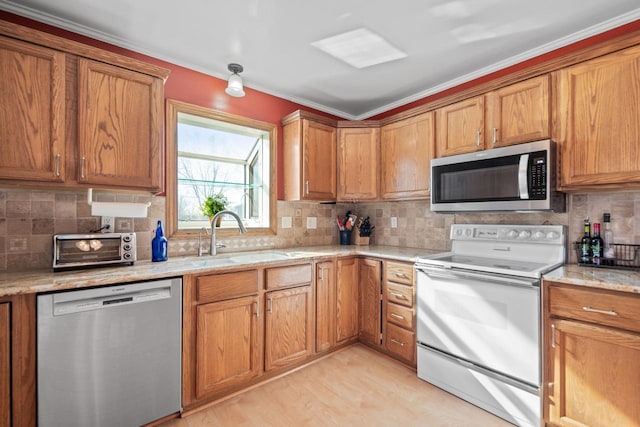 kitchen featuring a sink, stainless steel appliances, tasteful backsplash, and brown cabinetry