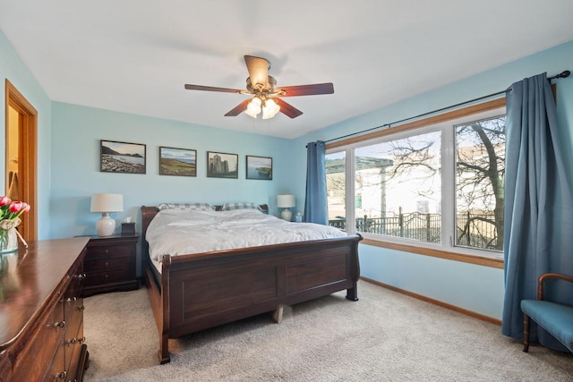 bedroom featuring light colored carpet, baseboards, and ceiling fan