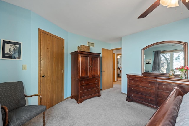 bedroom featuring light carpet, visible vents, and a ceiling fan