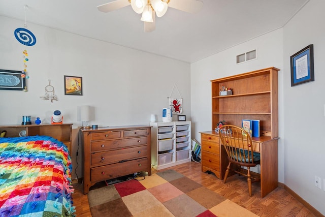 bedroom with visible vents, baseboards, wood finished floors, and a ceiling fan