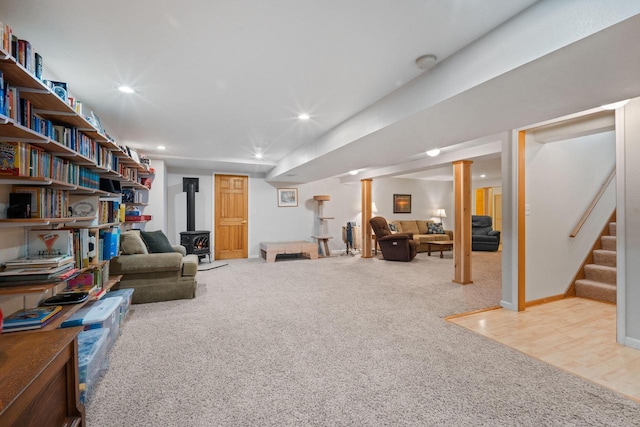 interior space with baseboards, stairway, carpet flooring, recessed lighting, and a wood stove