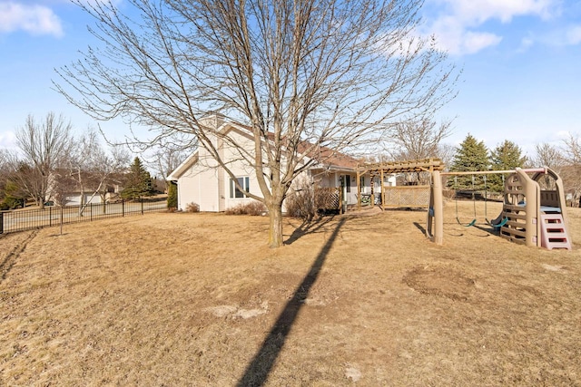 view of yard featuring a playground, fence, and a pergola