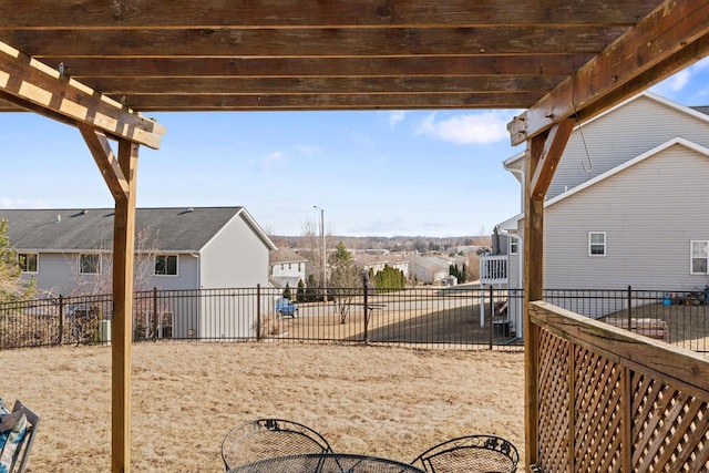 view of yard featuring a residential view, a pergola, and fence