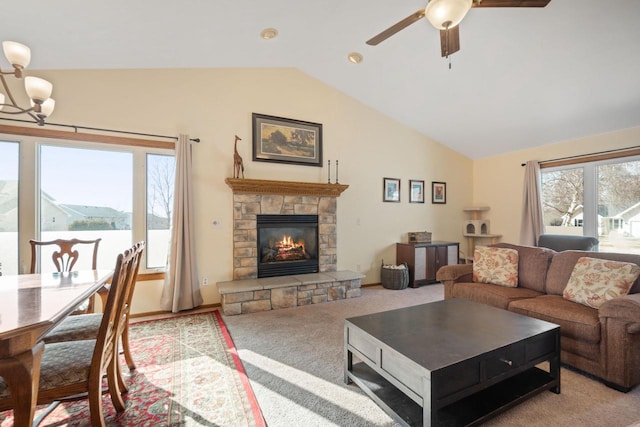 living room featuring ceiling fan with notable chandelier, lofted ceiling, a fireplace, and light carpet