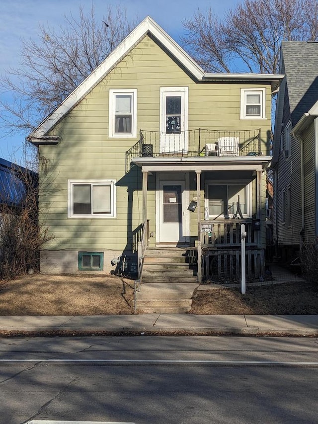 traditional-style home featuring a balcony and covered porch