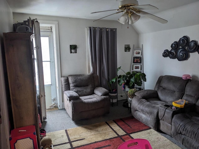 carpeted living area with a ceiling fan and vaulted ceiling