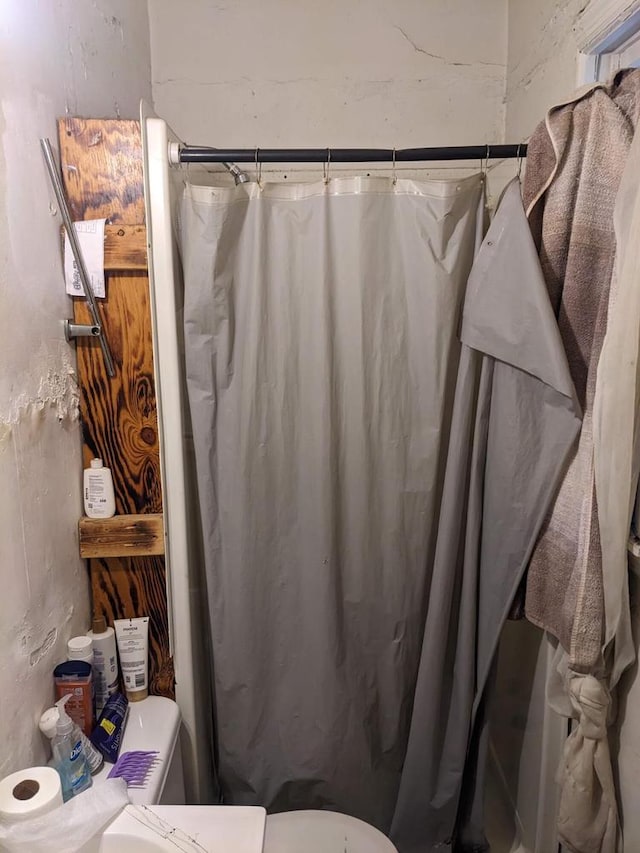 bathroom with a shower with shower curtain and toilet