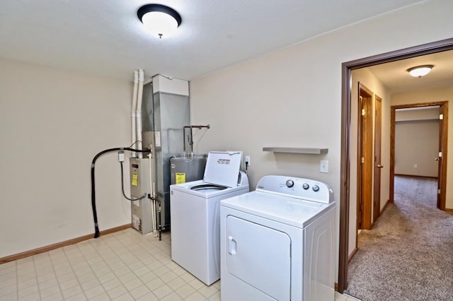 washroom with washing machine and dryer, electric water heater, light carpet, laundry area, and baseboards