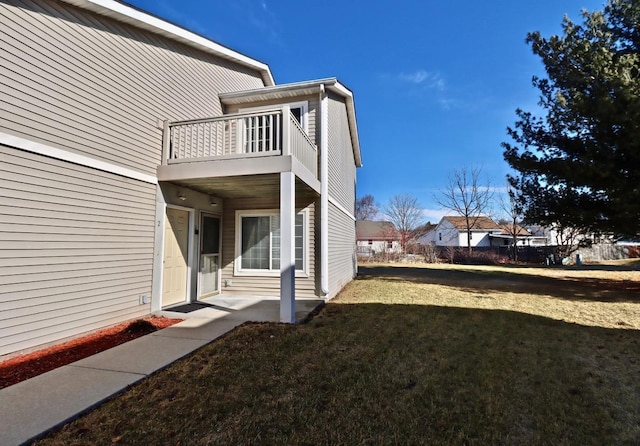 view of property exterior featuring a yard and a balcony